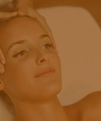 Young woman receiving a head massage in a spa center.